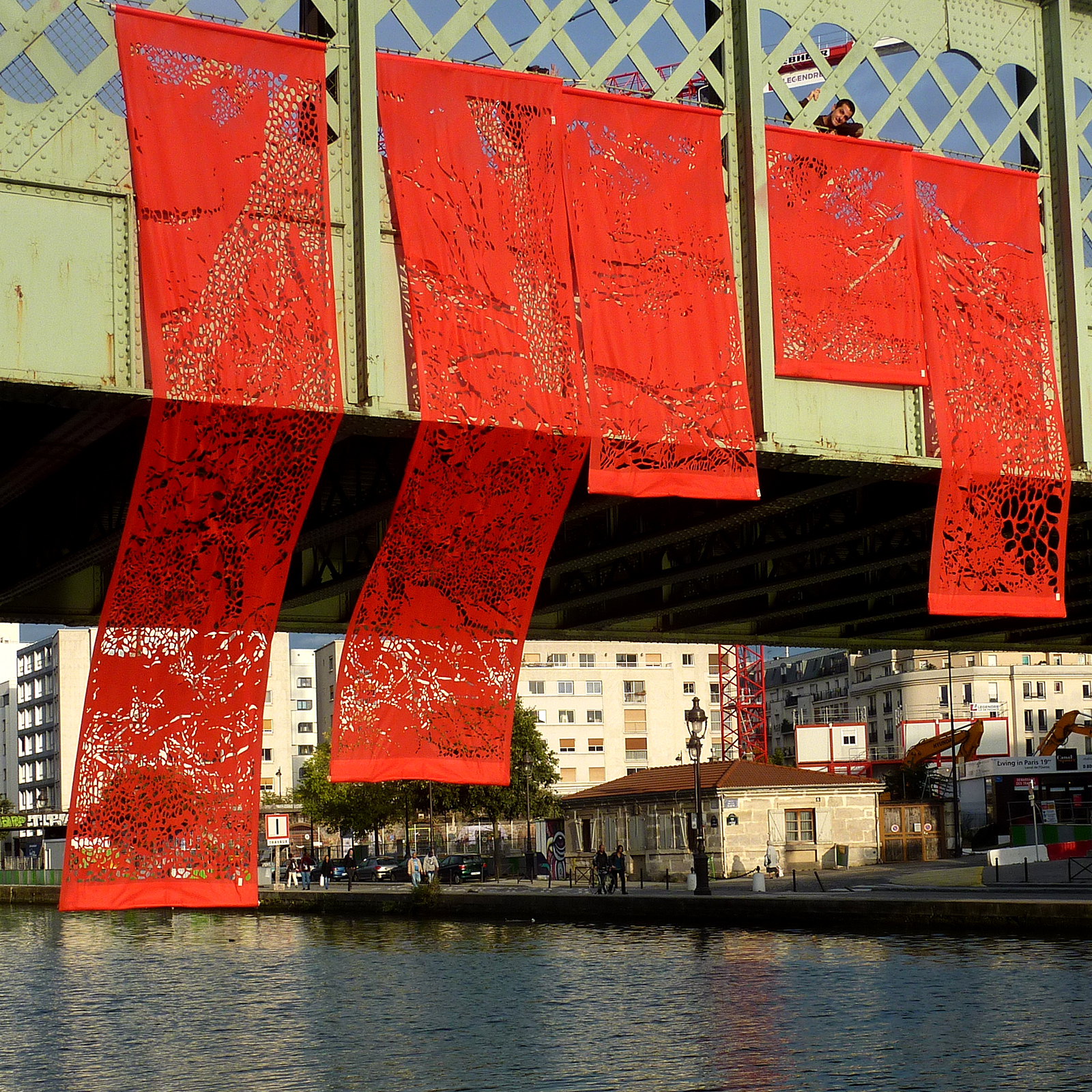 Installation géante composée de 5 kakémonos de papier découpé suspendus sur le pont de l'Ourcq